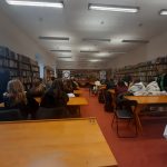 ludzie siedzący w ławkach