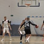 Gracz AZS AGH Kraków z numerem 24 rusza na kosz UJK Kielce, zawodnik AZS UJK Kielce próbuje odebrać piłkę, kolejny w tle