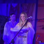 ShataQS gra na bębnie oceanicznym, za nią dwie chórzystki