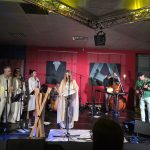 ShataQS używa bębna oceanicznego, zespół gra muzykę