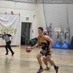 Zawodnik Basket Hills Bielsko-Biała rusza spod swojego kosza na kosz UJK Kielce, w tle jego współzawodnik oraz biegnący arbiter meczu